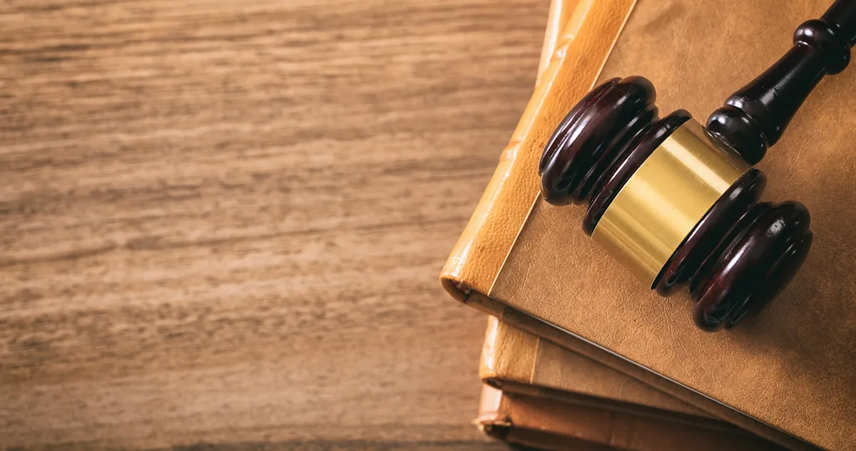 Judge gavel on law books wooden desk top view